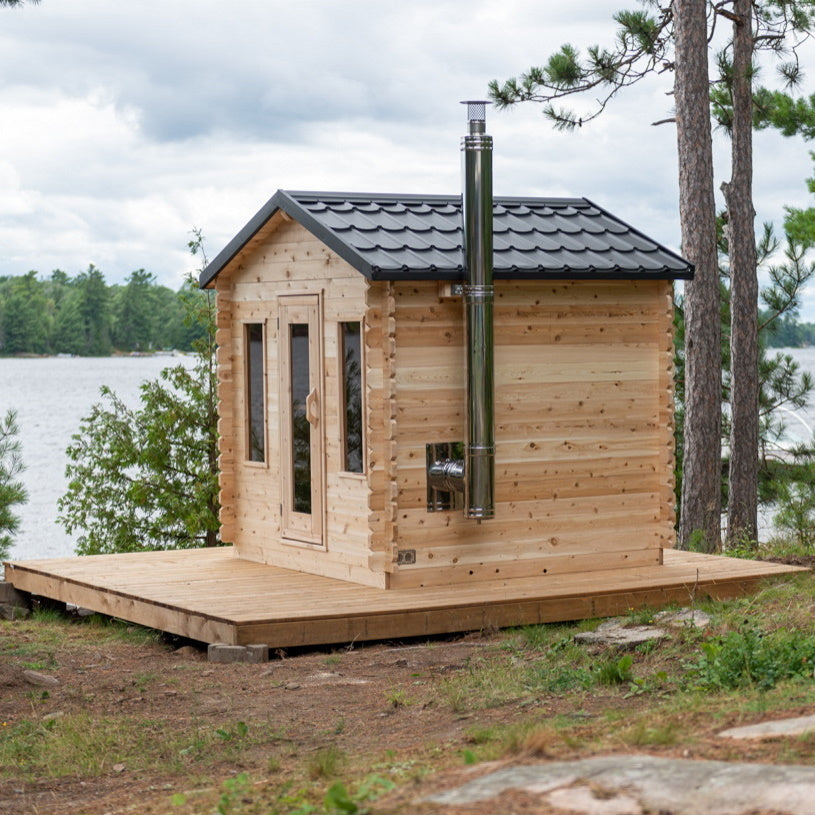 Dundalk Canadian Timber Georgian Cabin Sauna CTC88W - Eastern White Cedar with bronze tempered glass with wooden frame door and windows - with Harvia Chimney & Heat Shield set on side wall sauna - Outdoor setting - Vital Hydrotherapy