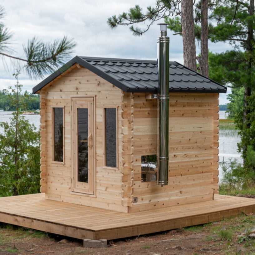 Dundalk Canadian Timber Georgian Cabin Sauna CTC88W - Eastern White Cedar with bronze tempered glass with wooden frame door and windows - with Harvia Chimney & Heat Shield set on side wall sauna - Outdoor setting - Vital Hydrotherapy