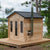 Dundalk Canadian Timber Georgian Cabin Sauna CTC88W - Eastern White Cedar with bronze tempered glass with wooden frame door and windows - with Harvia Chimney & Heat Shield set on side wall sauna - Outdoor setting - Vital Hydrotherapy